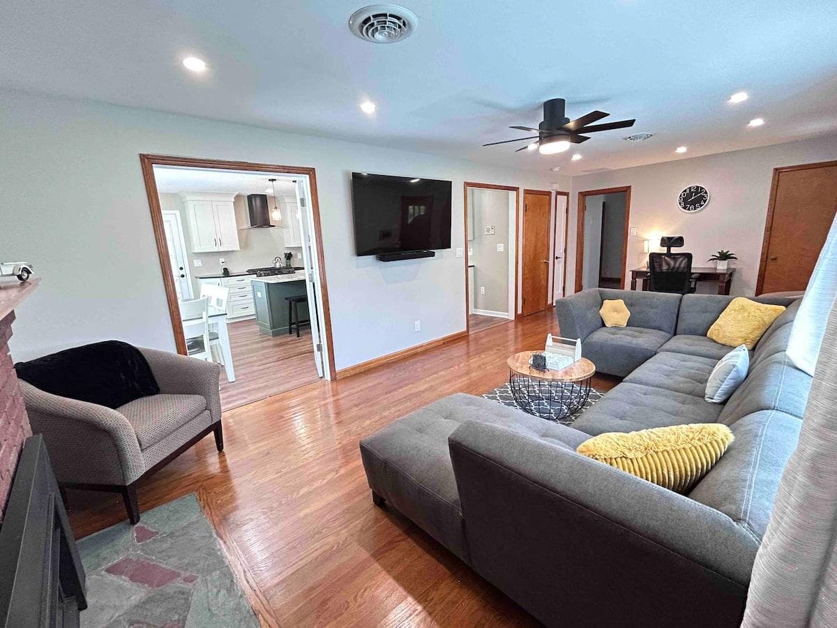 Living room into the kitchen. Bright, spacious, and comfortable. 65" SMART Tv with Sound Bar, fire place, dimmable lights, hard wood floors.